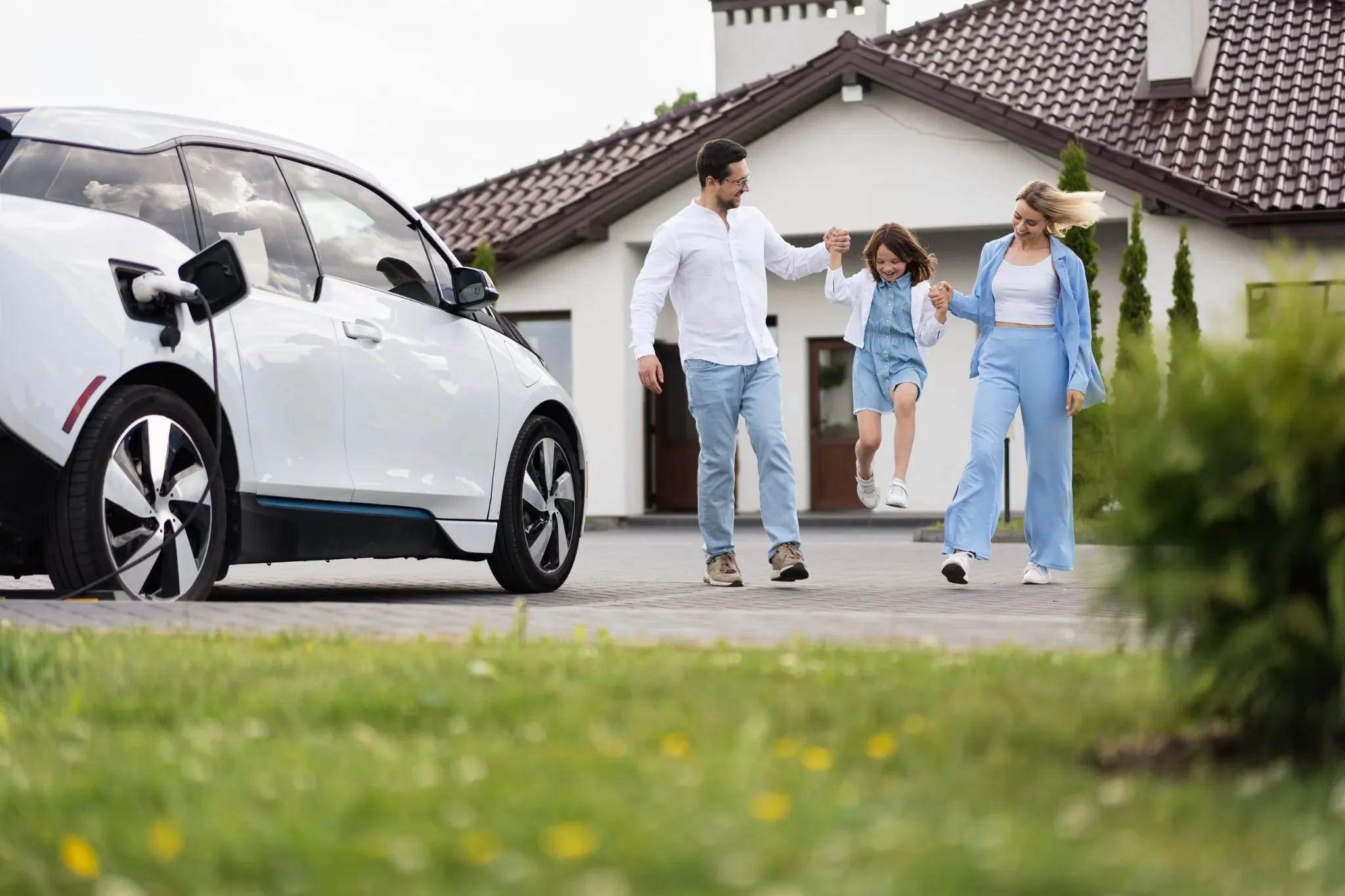 Family by a car outside a home